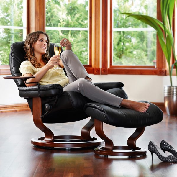 Stressless Sunrise Classic Recliner and Ottoman in Paloma Black with a Walnut Base, Swing Table and a Reclined Lady